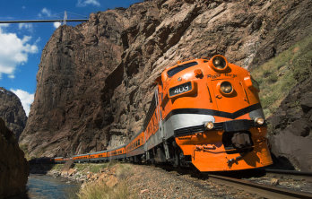 The bright orange Train on a mountainous Cliff near Happy Acres RV Park in Pueblo Colorado Courtesy of Royal Gorge Route Railroad